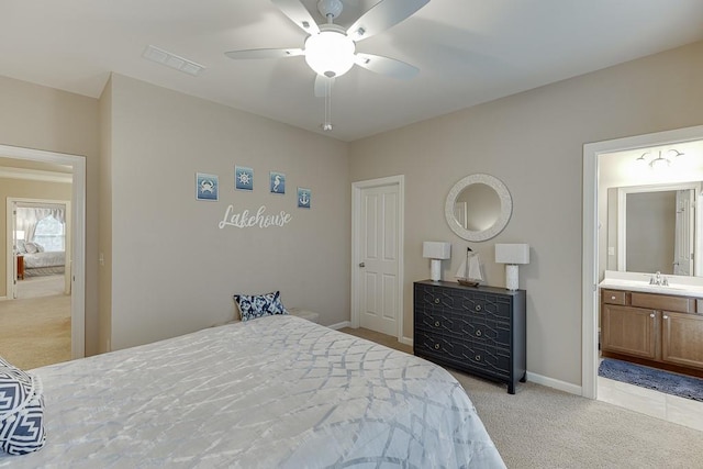 bedroom featuring baseboards, visible vents, a sink, light colored carpet, and connected bathroom