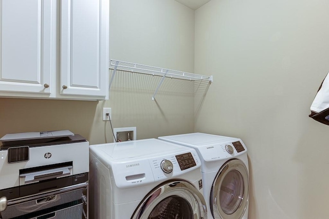 washroom with cabinet space and washing machine and clothes dryer