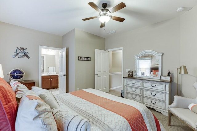 bedroom with visible vents, light colored carpet, ensuite bath, and a ceiling fan