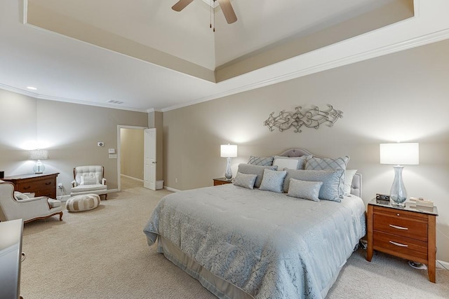 bedroom with ornamental molding, a tray ceiling, baseboards, light colored carpet, and ceiling fan