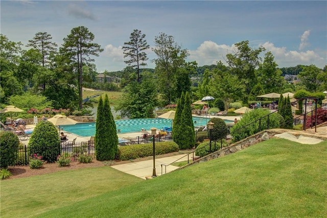 view of home's community with a pool, a patio, a yard, and fence