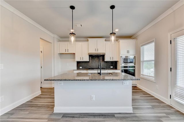 1620 Branthaven Ln, Auburn, GA 30011 - kitchen with appliances with stainless steel finishes, stone counters, white cabinets, backsplash, and a center island with sink