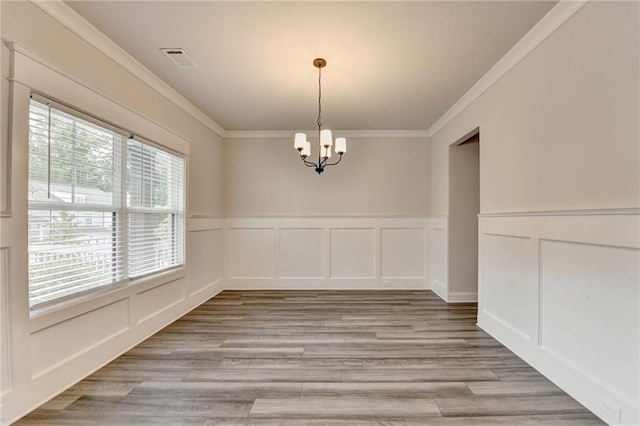 1620 Branthaven Ln, Auburn, GA 30011 - unfurnished dining area featuring a chandelier, a decorative wall, crown molding, light wood finished floors, and wainscoting