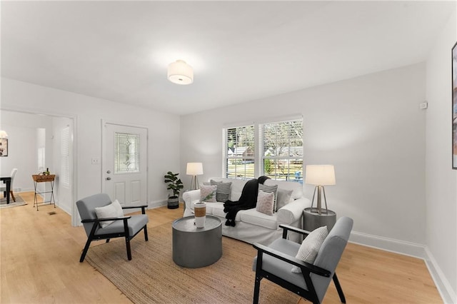 living area featuring light wood-type flooring and baseboards