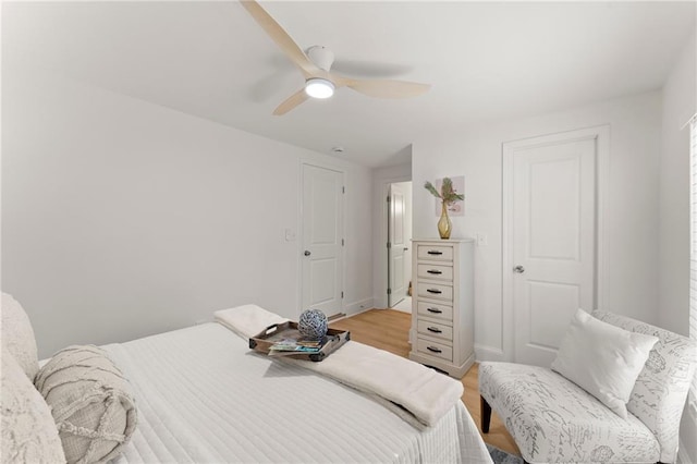 bedroom with baseboards, light wood finished floors, and ceiling fan