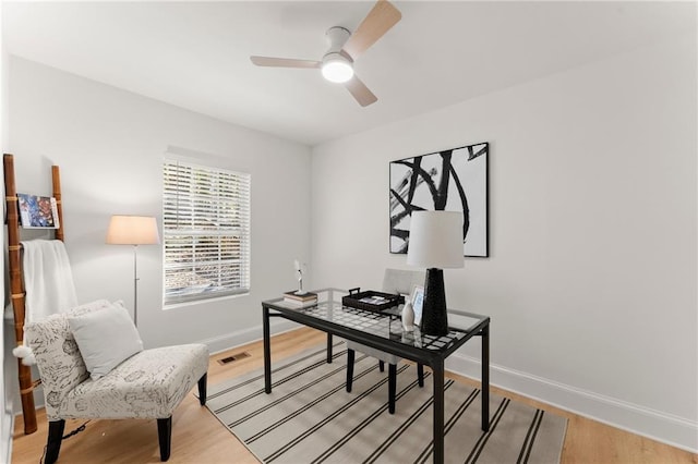 office area with visible vents, ceiling fan, light wood finished floors, and baseboards