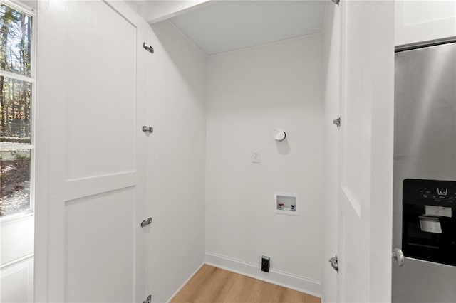 clothes washing area with laundry area, baseboards, washer hookup, and light wood-style floors