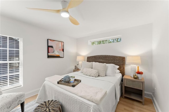 bedroom featuring ceiling fan, light wood-style flooring, and baseboards