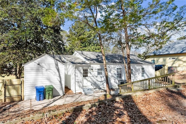 rear view of house with entry steps and fence