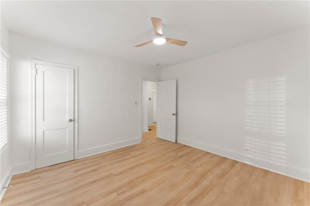 unfurnished bedroom with light wood-type flooring, multiple windows, and baseboards