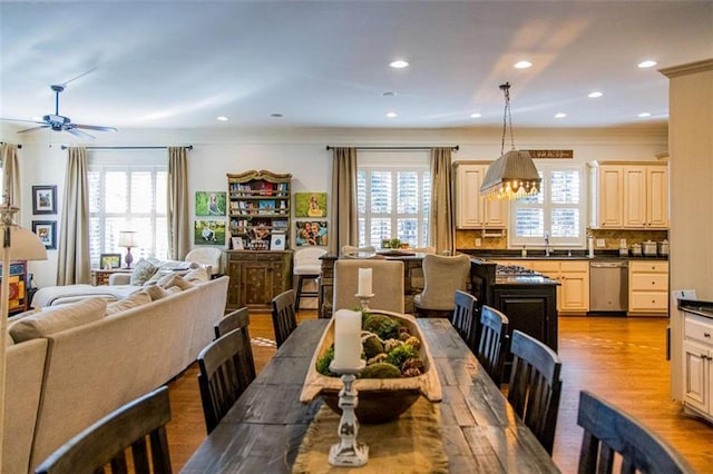 dining space with ornamental molding, recessed lighting, a healthy amount of sunlight, and light wood finished floors