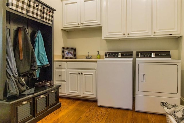 laundry area with dark wood-style flooring, cabinet space, independent washer and dryer, and a sink