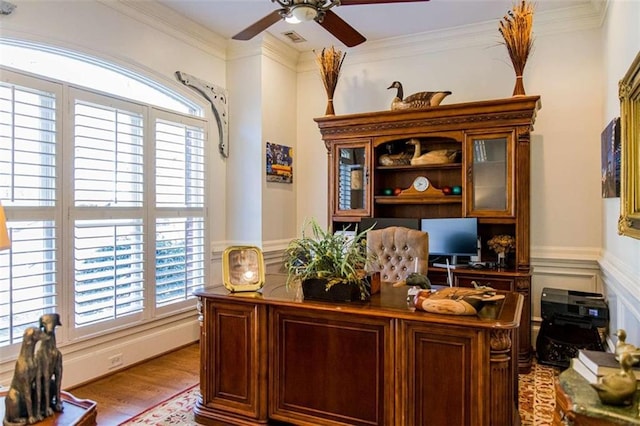 office featuring wainscoting, visible vents, light wood finished floors, and ornamental molding