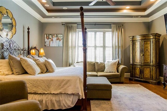 bedroom featuring dark wood-style flooring, a raised ceiling, crown molding, and recessed lighting