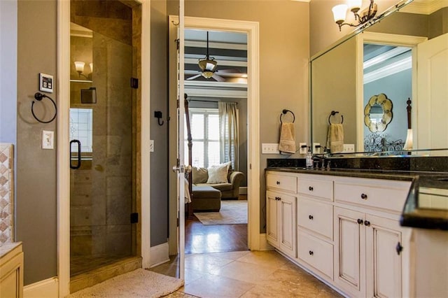 full bathroom with baseboards, vanity, a shower stall, and ceiling fan with notable chandelier