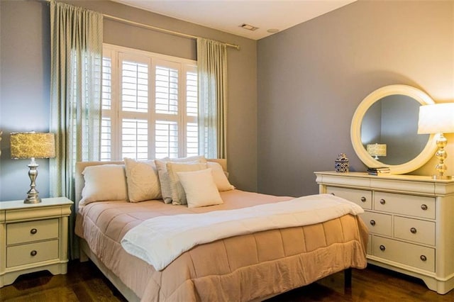 bedroom with visible vents and dark wood-style flooring