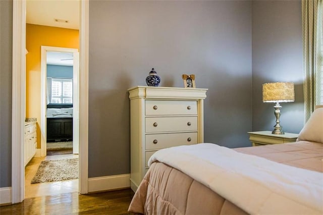 bedroom featuring visible vents, baseboards, and wood finished floors