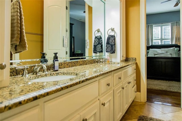 ensuite bathroom featuring tile patterned floors, ceiling fan, a sink, and ensuite bathroom