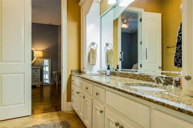 bathroom featuring ceiling fan, double vanity, a sink, and tile patterned floors