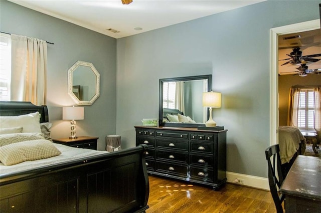 bedroom featuring dark wood-style floors, visible vents, and baseboards