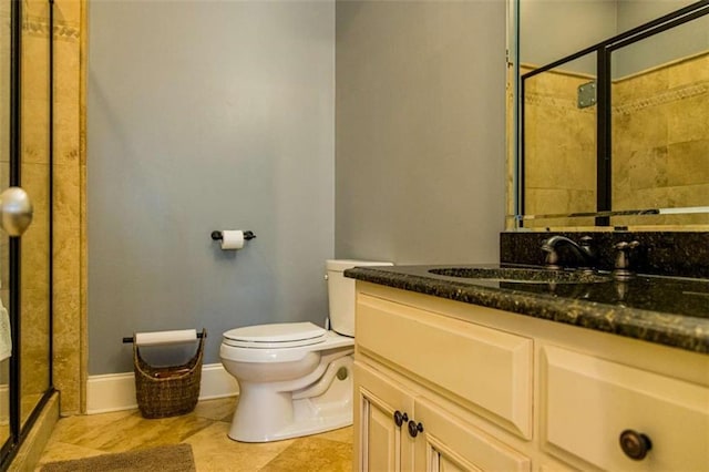 full bathroom featuring baseboards, vanity, toilet, and a shower stall