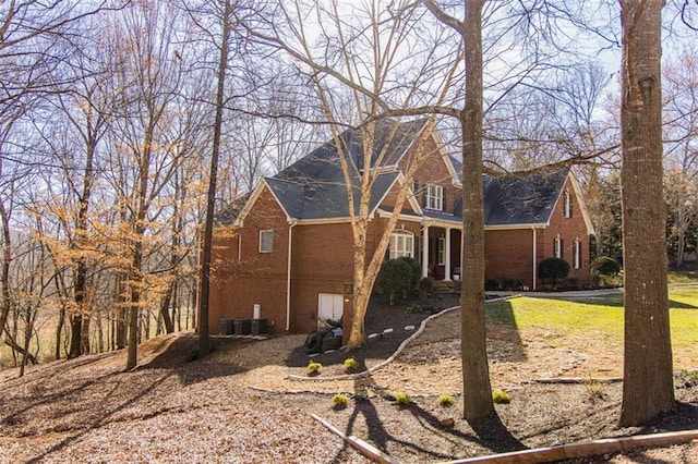 view of side of home featuring central AC and brick siding