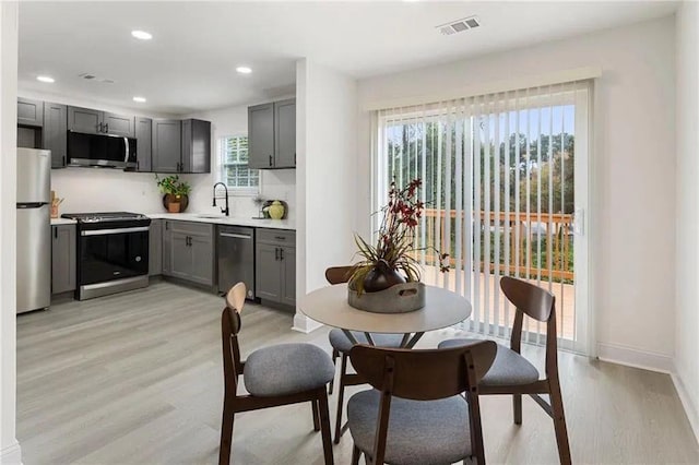 kitchen with stainless steel appliances, sink, and gray cabinetry