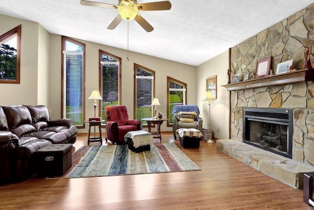 3491 Birchwood Trl, Snellville, GA 30078 - living area with ceiling fan, wood finished floors, a stone fireplace, and a textured ceiling