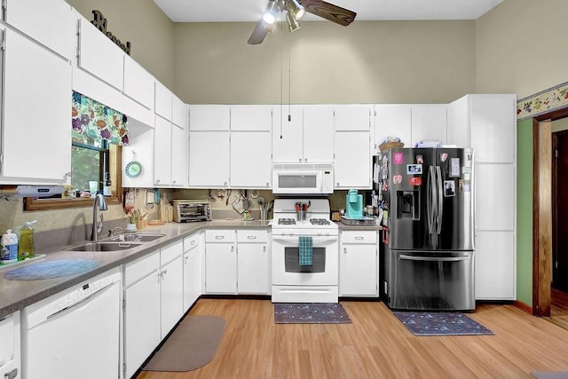 3491 Birchwood Trl, Snellville, GA 30078 - kitchen with white appliances, light wood finished floors, ceiling fan, white cabinets, and a towering ceiling