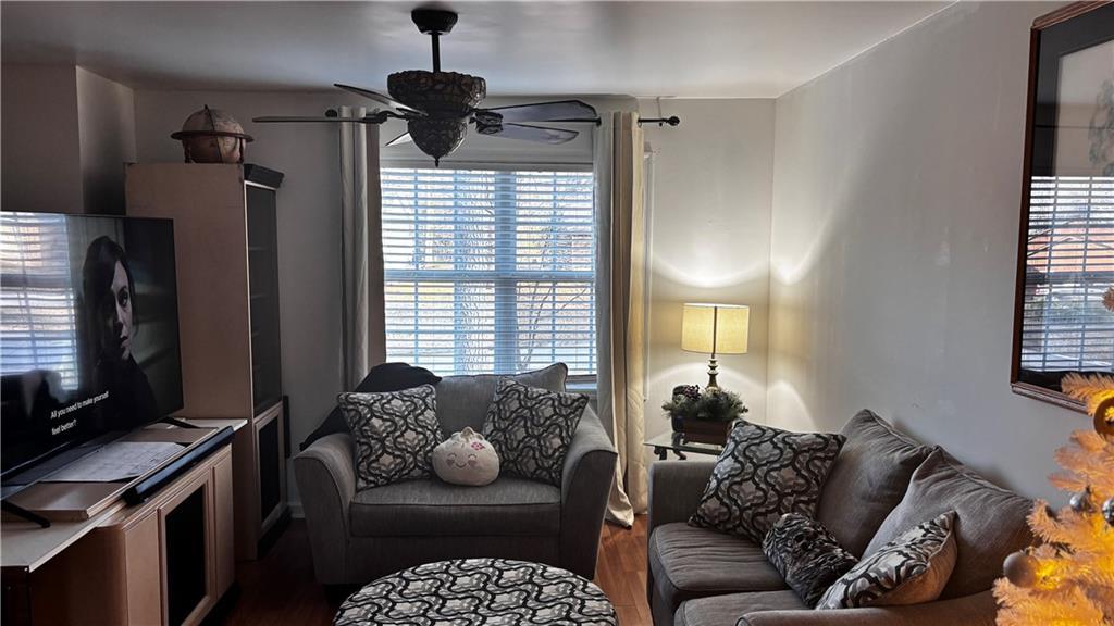 living room featuring a ceiling fan and wood finished floors