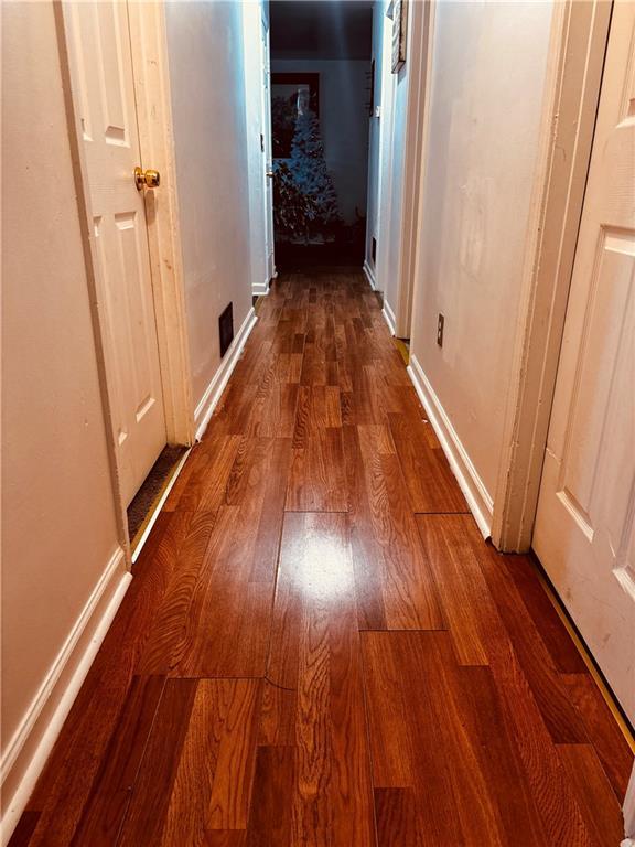 hall with wood finished floors and baseboards