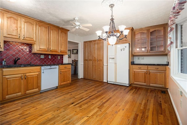 5247 Yeager Rd, Douglasville, GA 30135 - kitchen featuring white appliances, dark countertops, light wood-style floors, a sink, and glass insert cabinets