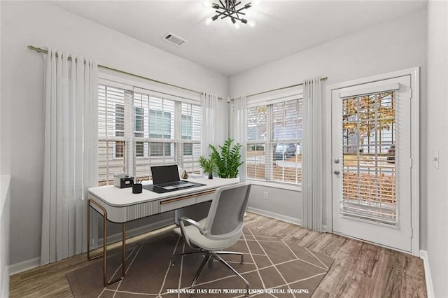 office space featuring wood-type flooring and a notable chandelier