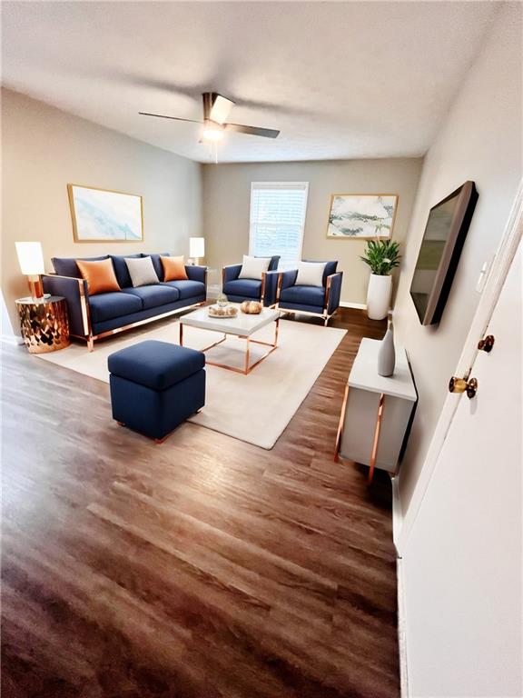 living room featuring ceiling fan and dark hardwood / wood-style flooring