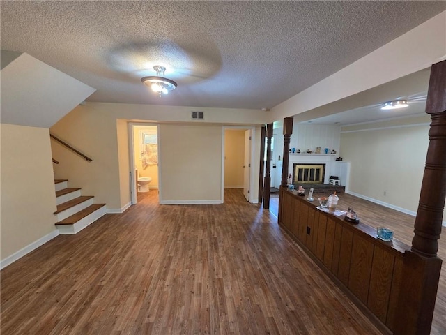 3400 Elm Creek Dr NW, Marietta, GA 30064 - unfurnished living room with wood finished floors, stairway, a textured ceiling, and a glass covered fireplace