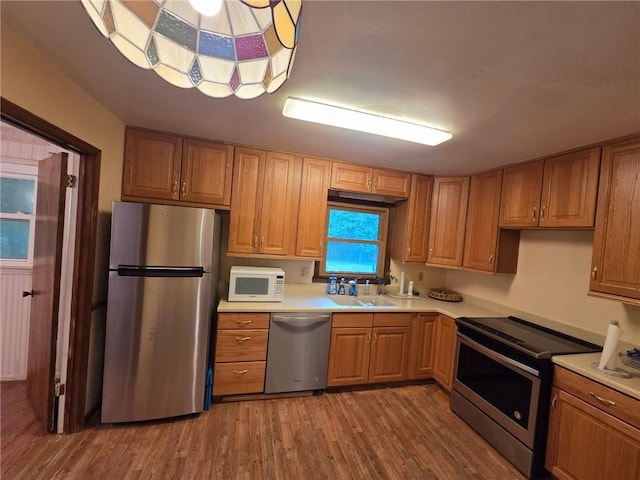 3400 Elm Creek Dr NW, Marietta, GA 30064 - kitchen with appliances with stainless steel finishes, wood finished floors, light countertops, and brown cabinetry