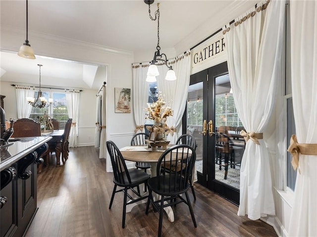 dining room with a healthy amount of sunlight, ornamental molding, dark hardwood / wood-style flooring, and a chandelier