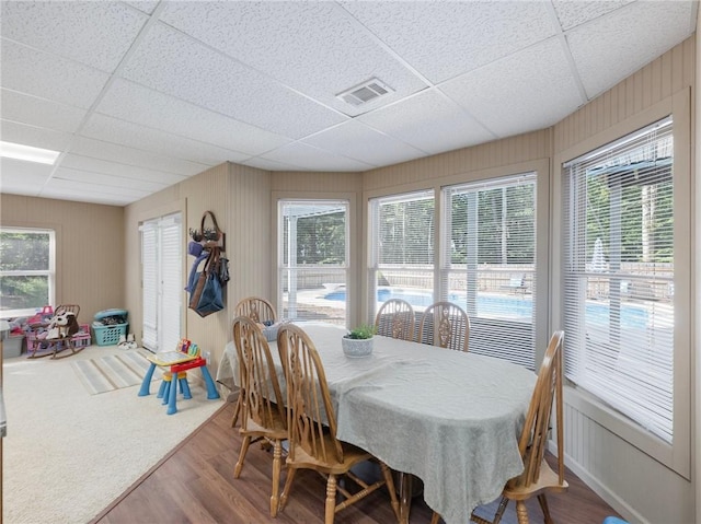 dining area featuring a drop ceiling and hardwood / wood-style flooring