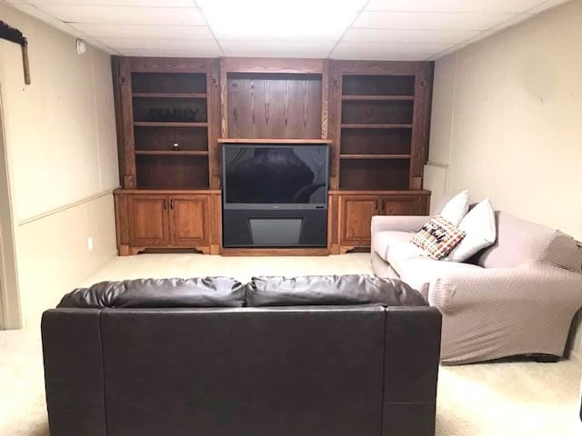 carpeted living room featuring a paneled ceiling