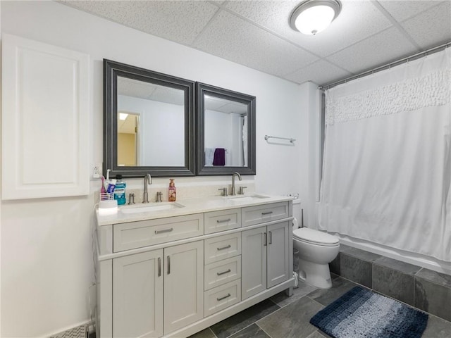 bathroom with vanity, a drop ceiling, tile patterned flooring, and toilet