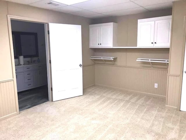 clothes washing area featuring light carpet and sink