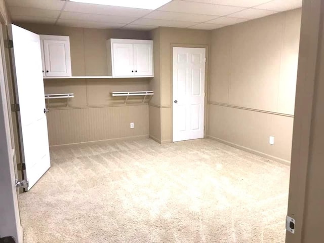 unfurnished bedroom featuring a paneled ceiling and light colored carpet