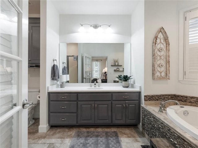 bathroom with tiled tub, vanity, and tile patterned floors