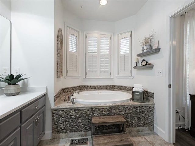 bathroom featuring vanity and a relaxing tiled tub