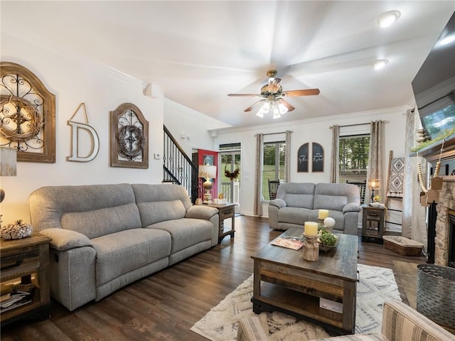 living room with ceiling fan, a fireplace, dark wood-type flooring, and crown molding