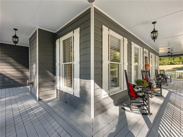 deck with ceiling fan and covered porch