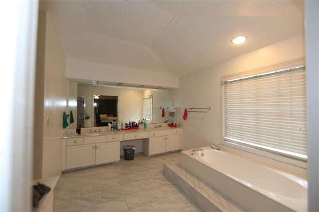 bathroom with a tub to relax in, vaulted ceiling, and vanity