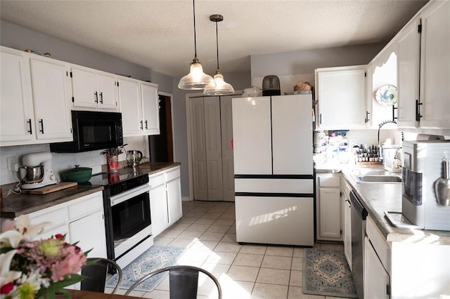 kitchen featuring white refrigerator, white cabinetry, hanging light fixtures, and electric stove