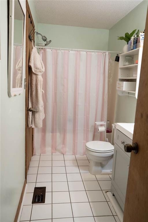 bathroom with vanity, toilet, tile patterned flooring, and a textured ceiling