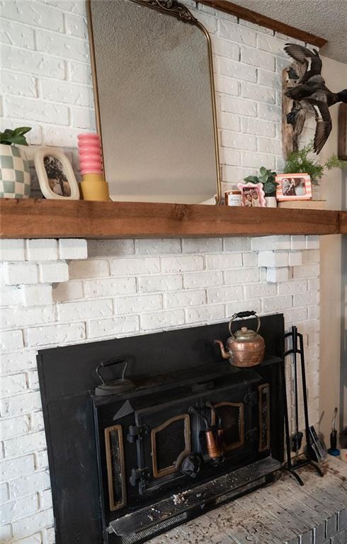 room details featuring a wood stove and a textured ceiling